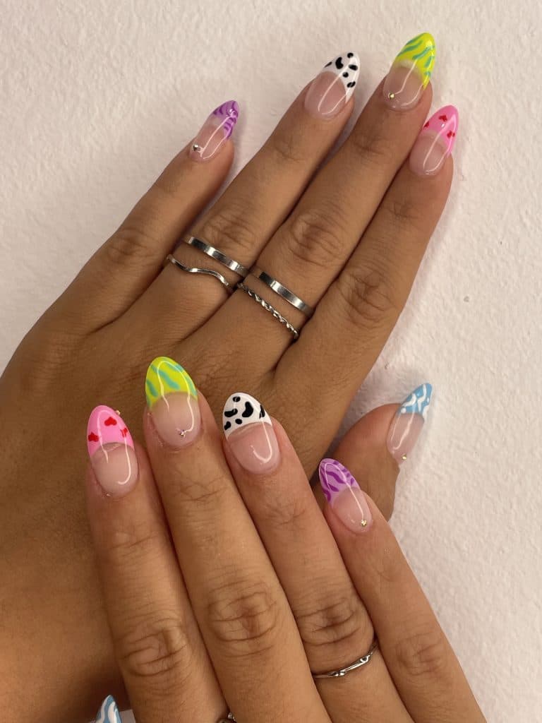 Mano con uñas alargadas mostrando un diseño transparente con detalles florales y adornos lineales.